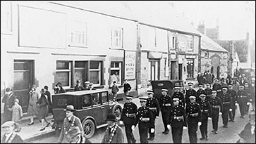 Members of the St John Ambulance Brigade parading past the Red Cow on Remembrance Day late 1920s
