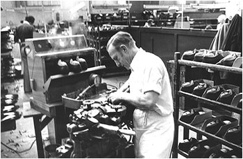 Photograph of Mr Hearn operatiing a machine in the Lasting Department