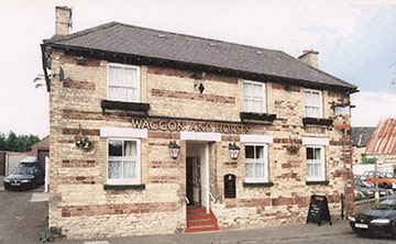 Recent photograph of The Waggon & Horses with car sales lot to the right.