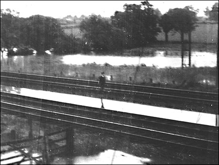 The Station Master Arthur Mutlow checking the flooded track in 1958