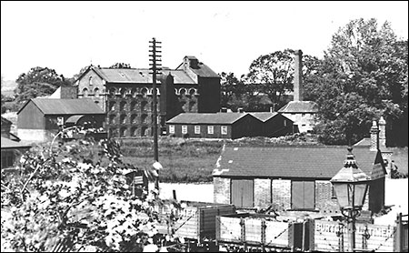Photograph showing Burton Latimer Goods Yard in the 1930s with Weetabix Mills in the background.  Burton Latimer Co-op Society coal wagons are in the forefront.