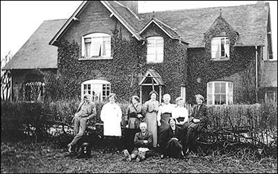 Standing L - R: Mr. Pike (a live-in farm worker), unknown, unknown, Louisa Downing (Bill Ross’s step-grandmother), Polly Downing, Alice Downing and Nell Downing. Seated are: Fred Downing and Rosa Downing.