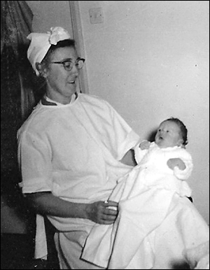 Margaret Atkinson at work holding a baby