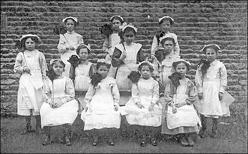 Photograph of Church School girls dressed as housemaids in 1900