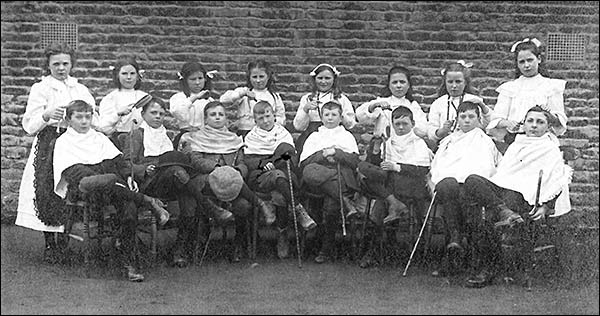 Photograph of Church School Boys and Girls showing the boys having haircuts by the girls in 1909