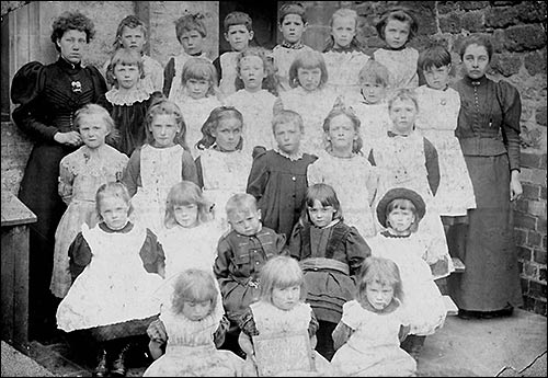 Photograph of pupils at Church Infant School with their teachers, Miss Drew and a teaching colleague