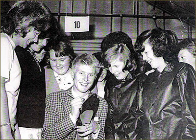 Photograph showing Joe Brown of Joe Brown and the Bruvvers signing a pair of Coles Group Shoes at the factory c1964