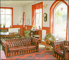 Photograph of the interior of the house depicting the lounge.