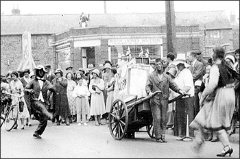 Street scene from about 1905. In the background, Eben Taylor stands at the doorway of his cobbler's business