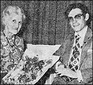 Mrs. Alice Dacre receiving a bouquet of flowers from Council Chairman  Nicholas Loake.