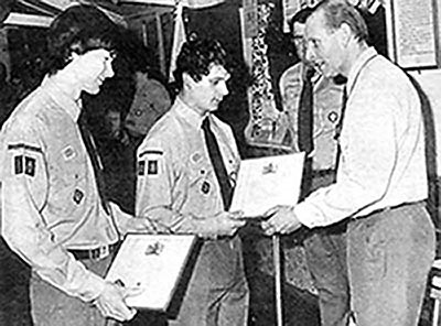 Paul Chennell and Harvey York receiving their Queen's Scout Awards from John Tilley, Assistant County Comissioner for Scouts