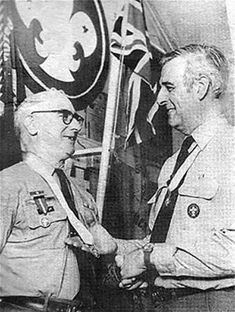 Veteran Scout, George Ramsbottom receiving the Silver Acorn Medallion from County Commissioner, Michael Lane