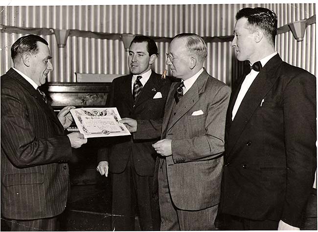 Bob Phillips receiving a British Legion Long Service Award from the branch president, Mr Frank T Peck.  Looking on are Dennis Long (centre back) and Fred Wells c1956